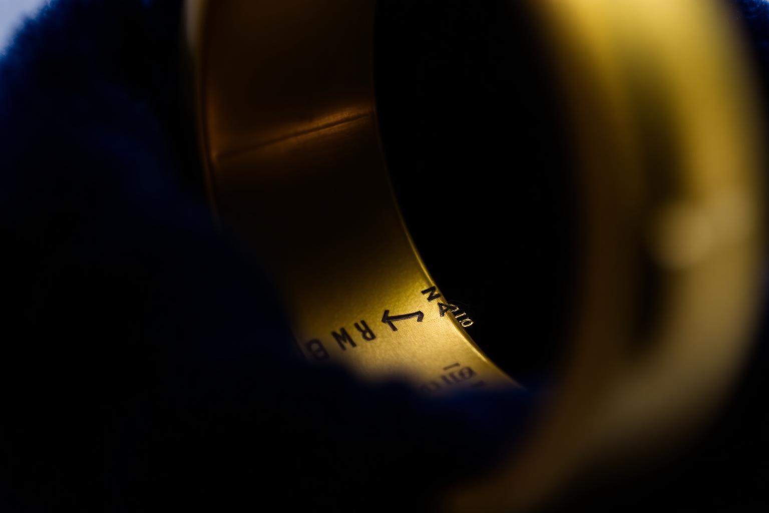 Macro shot of hallmarks inside a gold ring shank on dark velvet